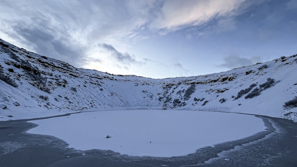 a snow covered mountain with a lake in the middle