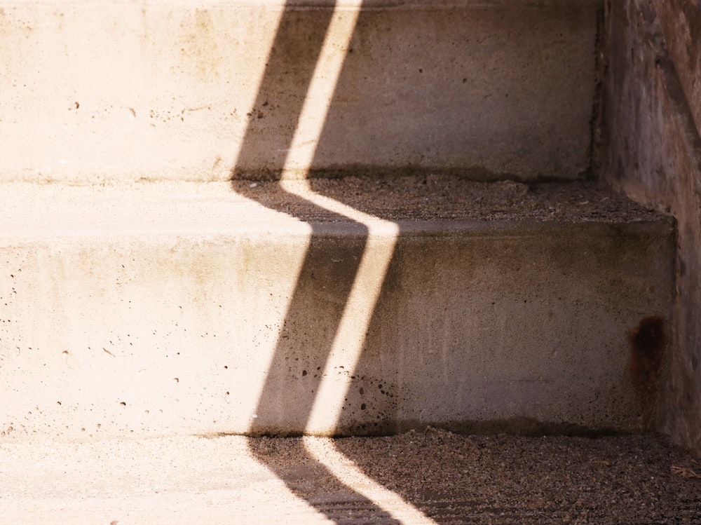 a shadow of a person walking up some steps