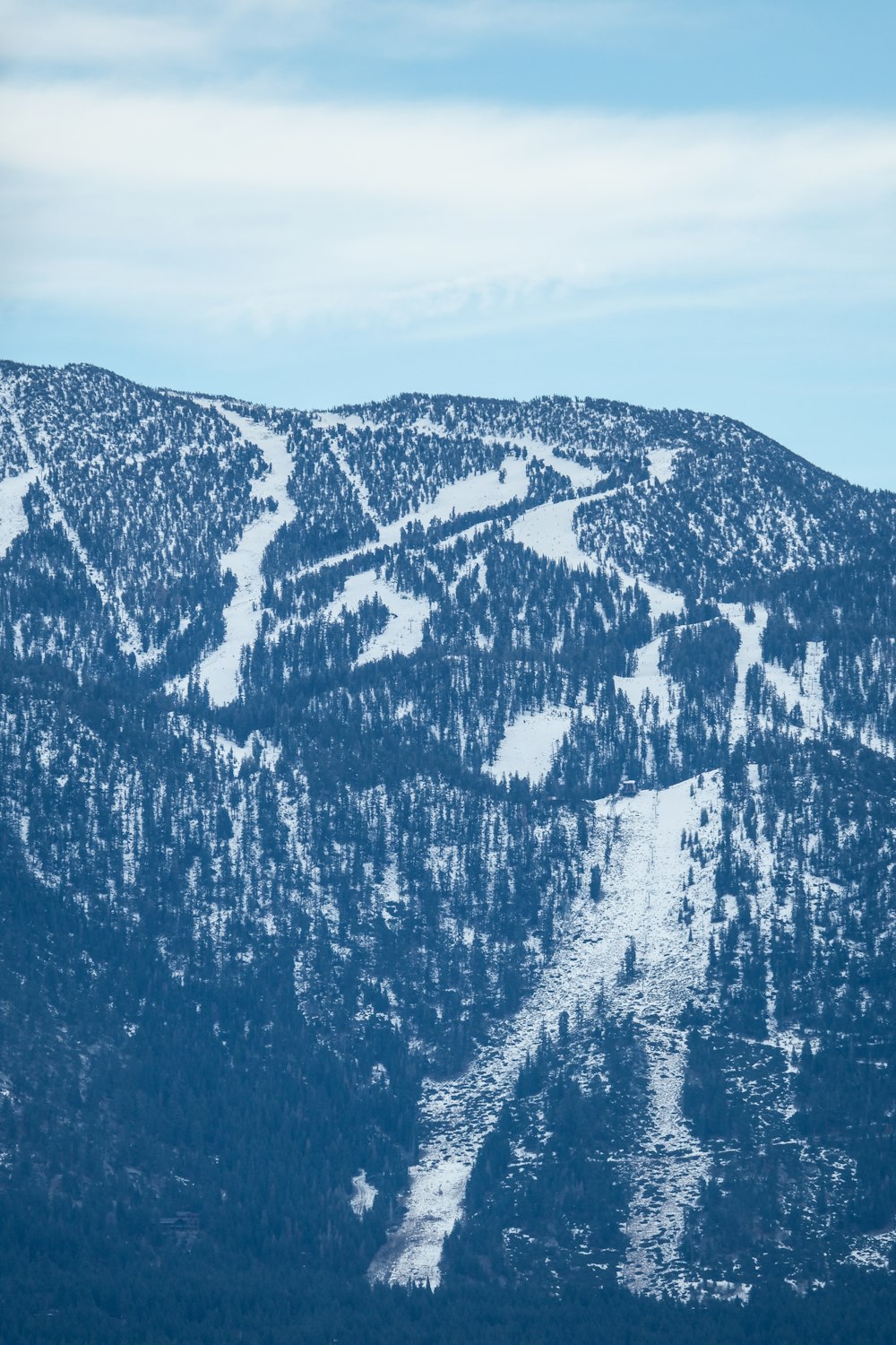 a mountain covered in snow with a ski slope in the background