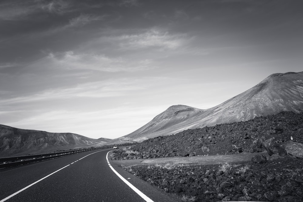 a black and white photo of a mountain road