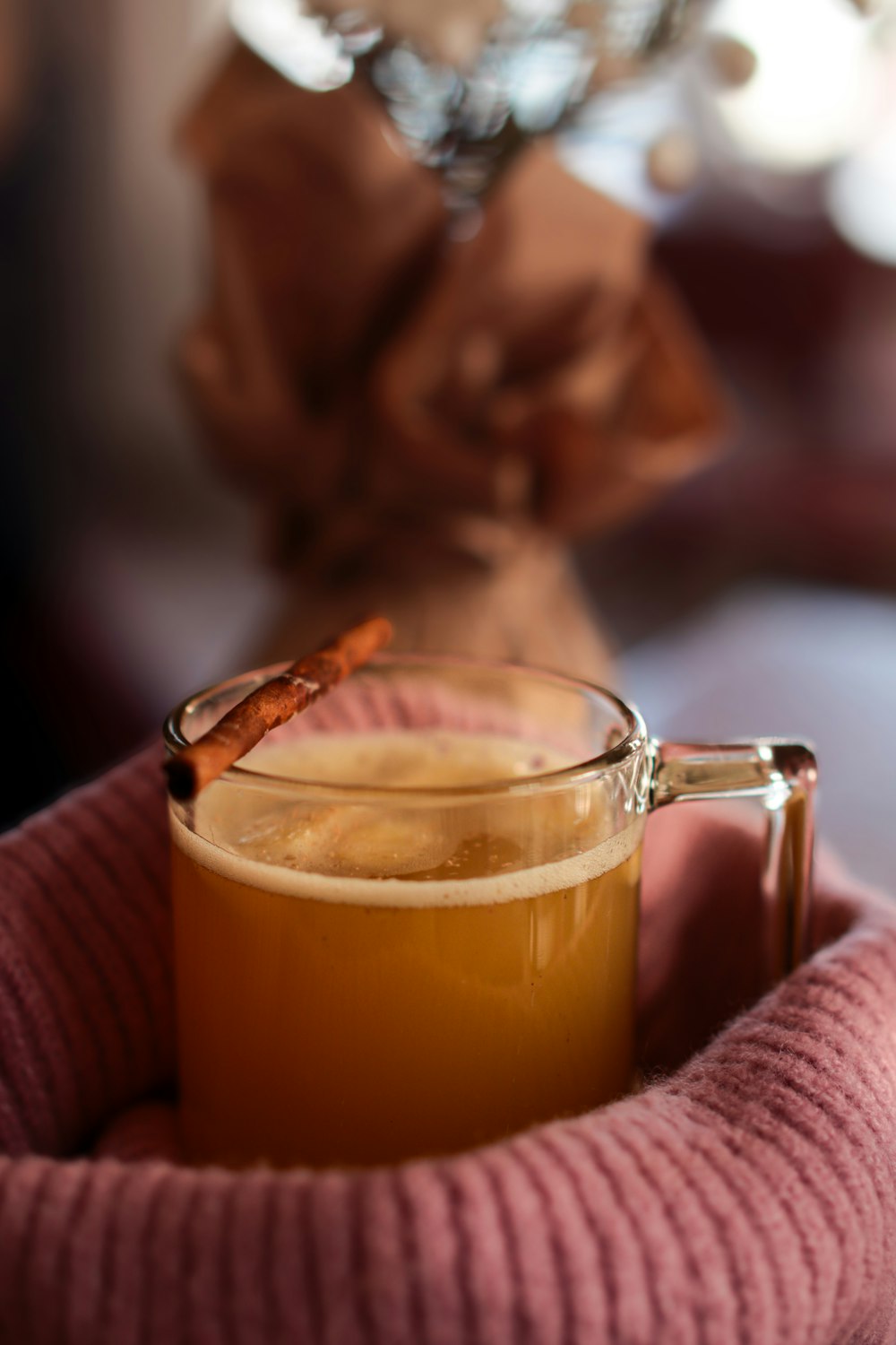 una taza de té sentada encima de una manta rosa