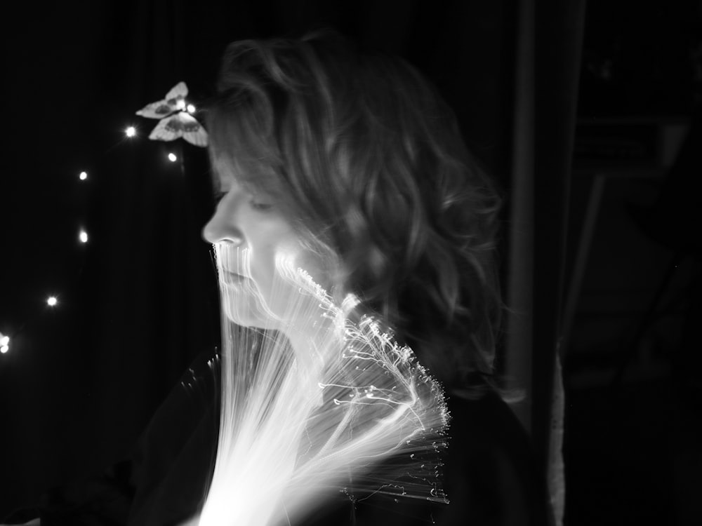 a black and white photo of a woman with a flower in her hair