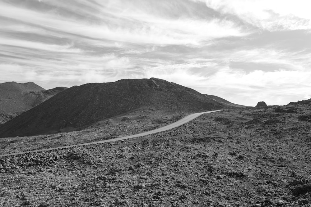 a black and white photo of a mountain road