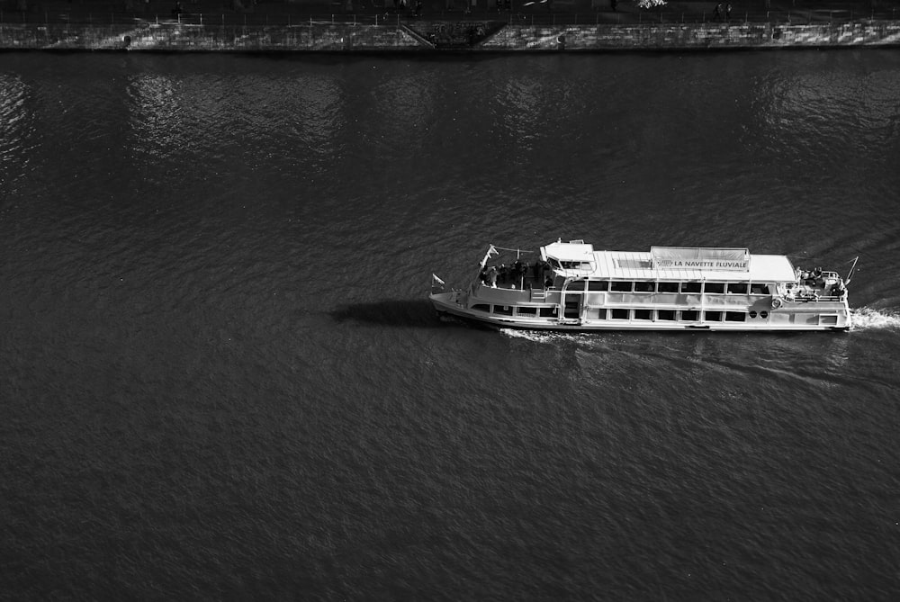 a large boat traveling down a river next to a bridge