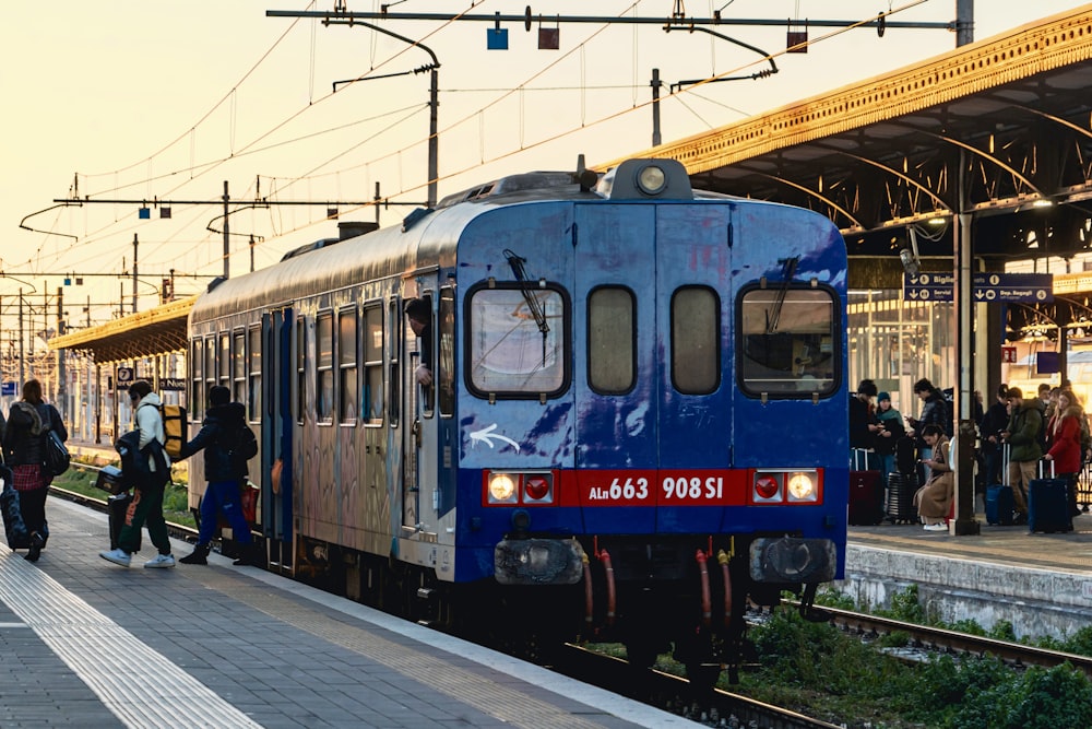 a blue train pulling into a train station