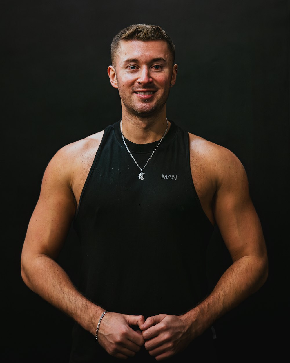 a man in a black tank top posing for a picture