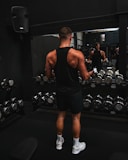 a man standing in front of a mirror in a gym