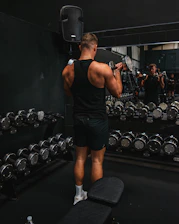 a man standing on a bench in a gym