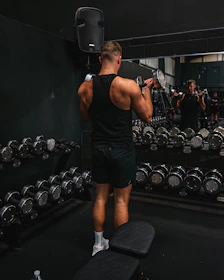 a man standing on a bench in a gym