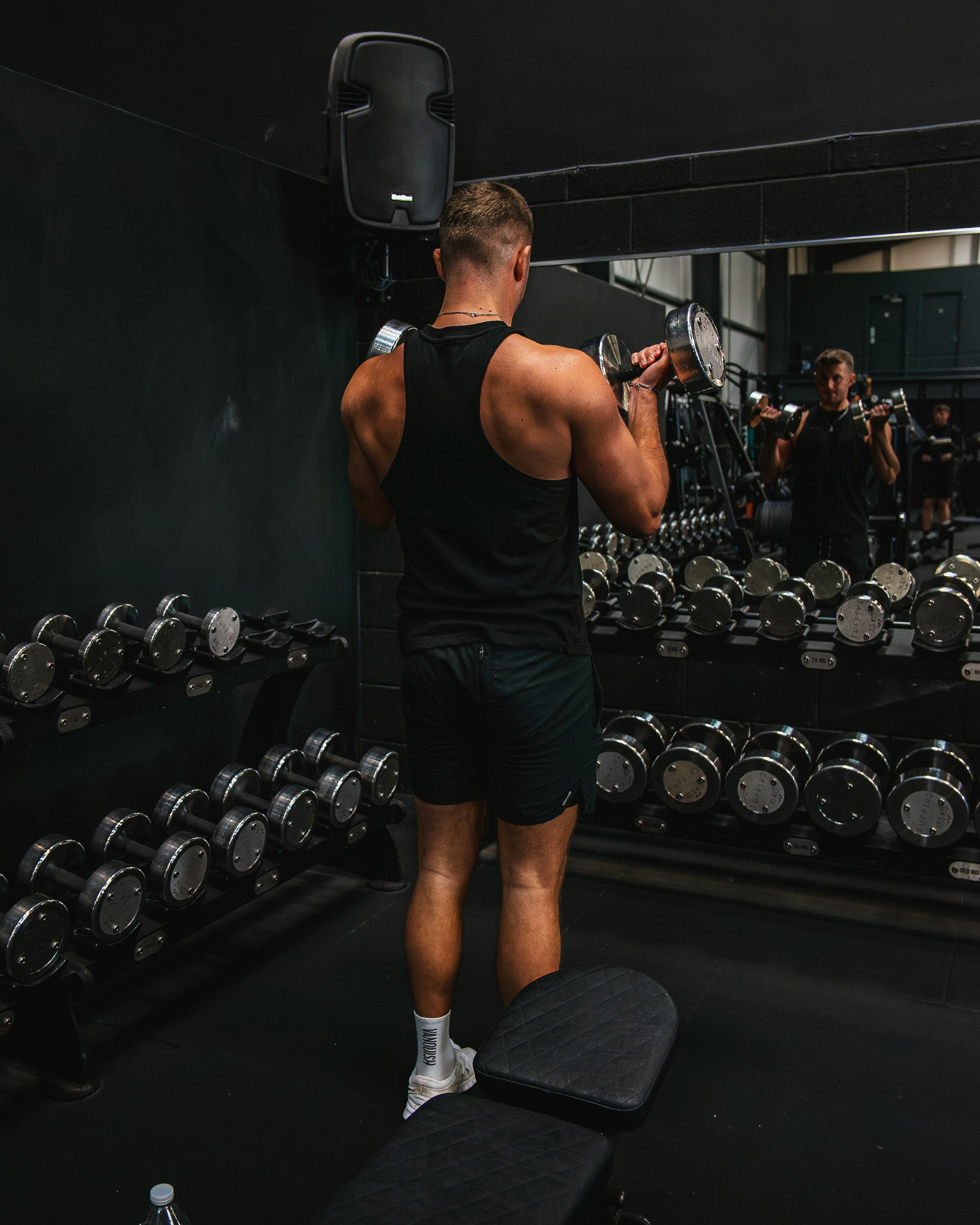 a man standing on a bench in a gym