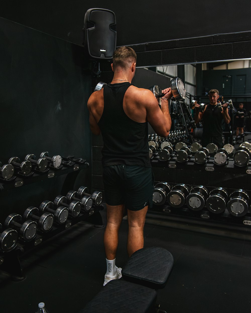 a man standing on a bench in a gym