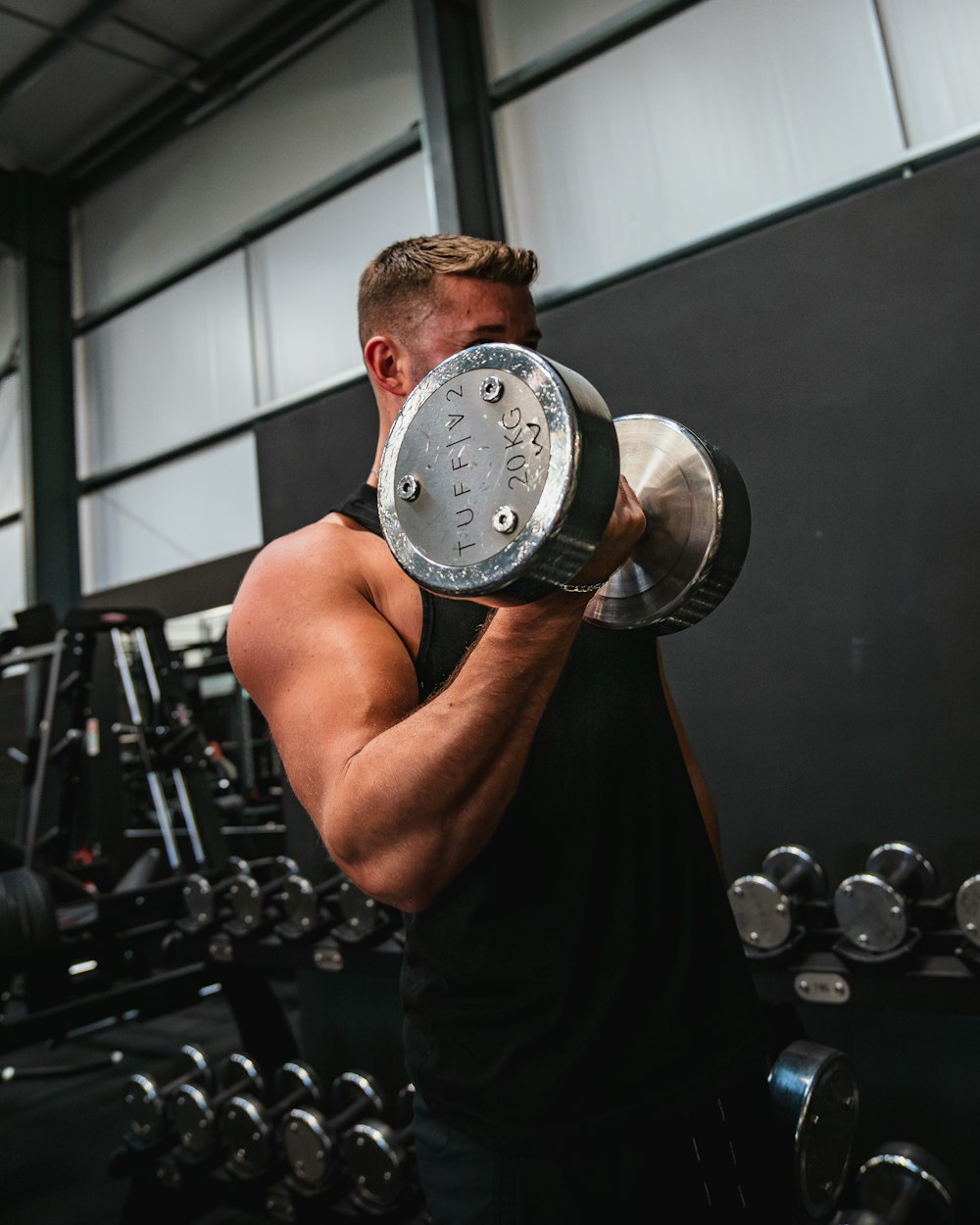 a man lifting a dumbbell in a gym