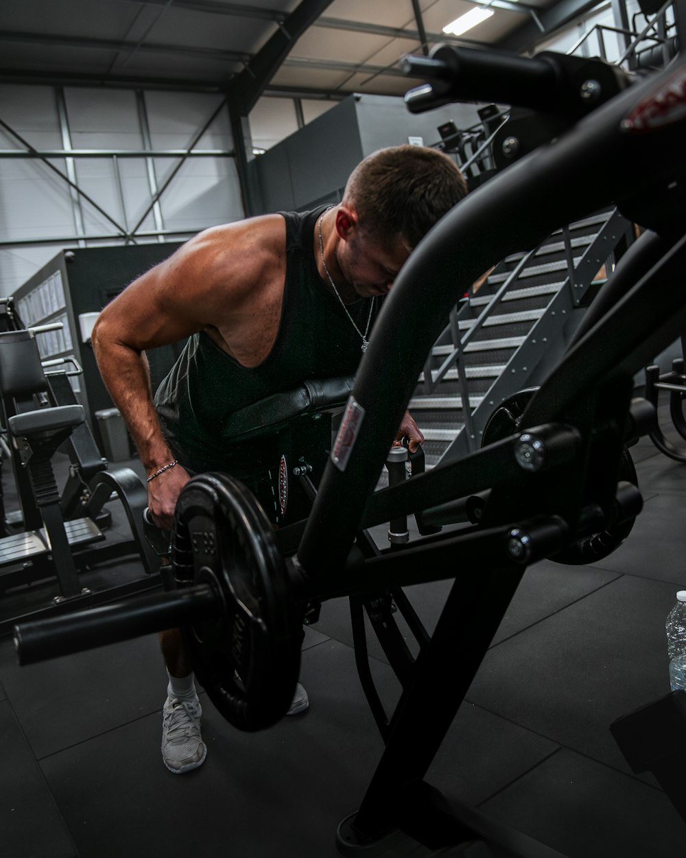 a man squatting down with a barbell in a gym