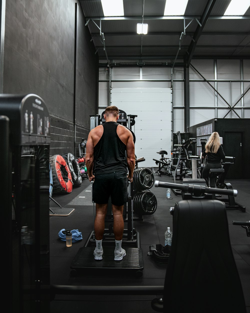 a man standing on a weight machine in a gym