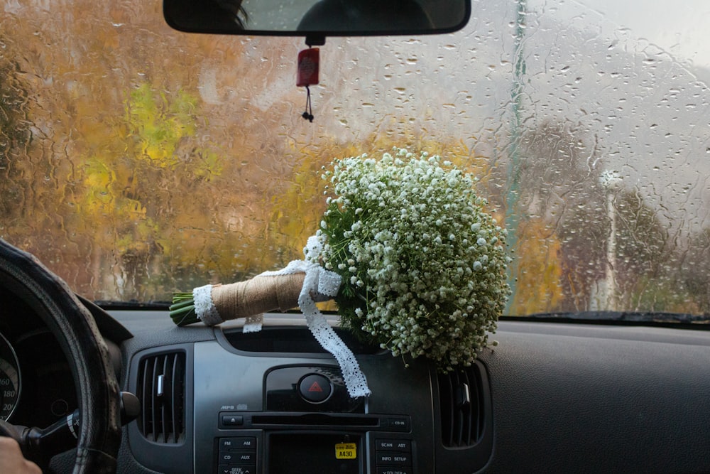 a car dashboard with a flower arrangement on top of it