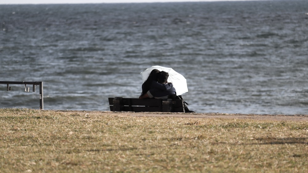 a person sitting on a bench near the water