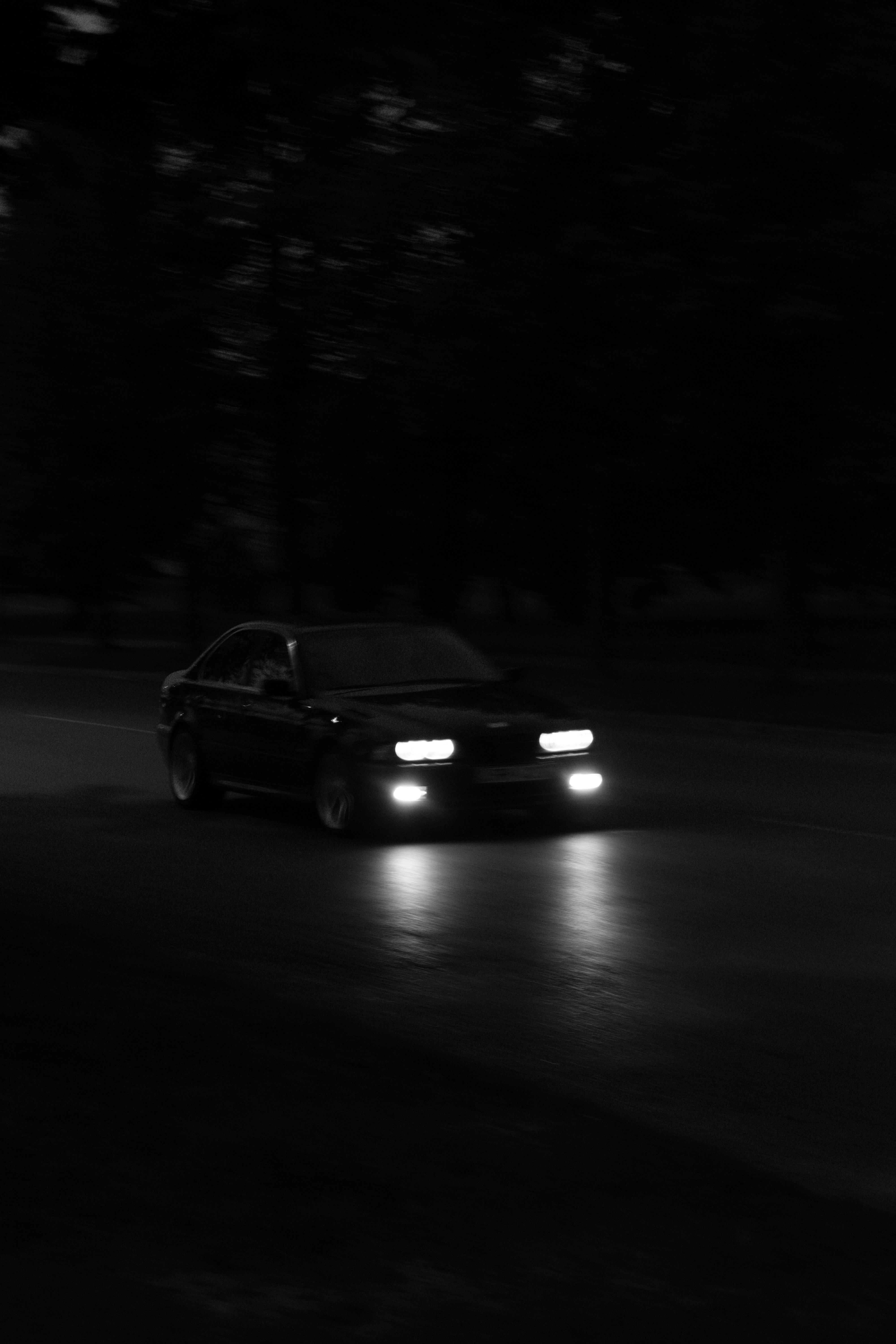 a car driving down a street at night