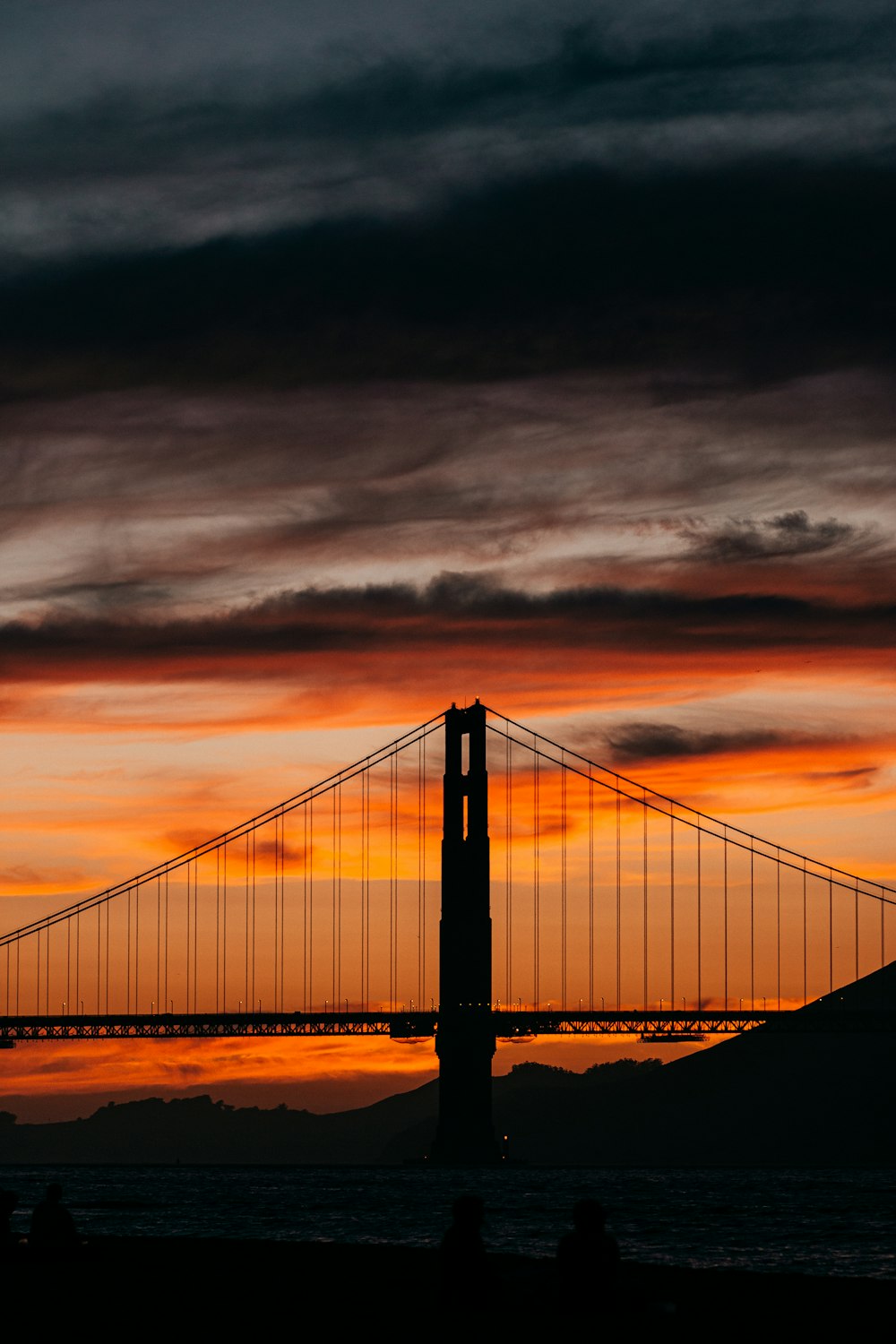 the golden gate bridge is silhouetted against a sunset