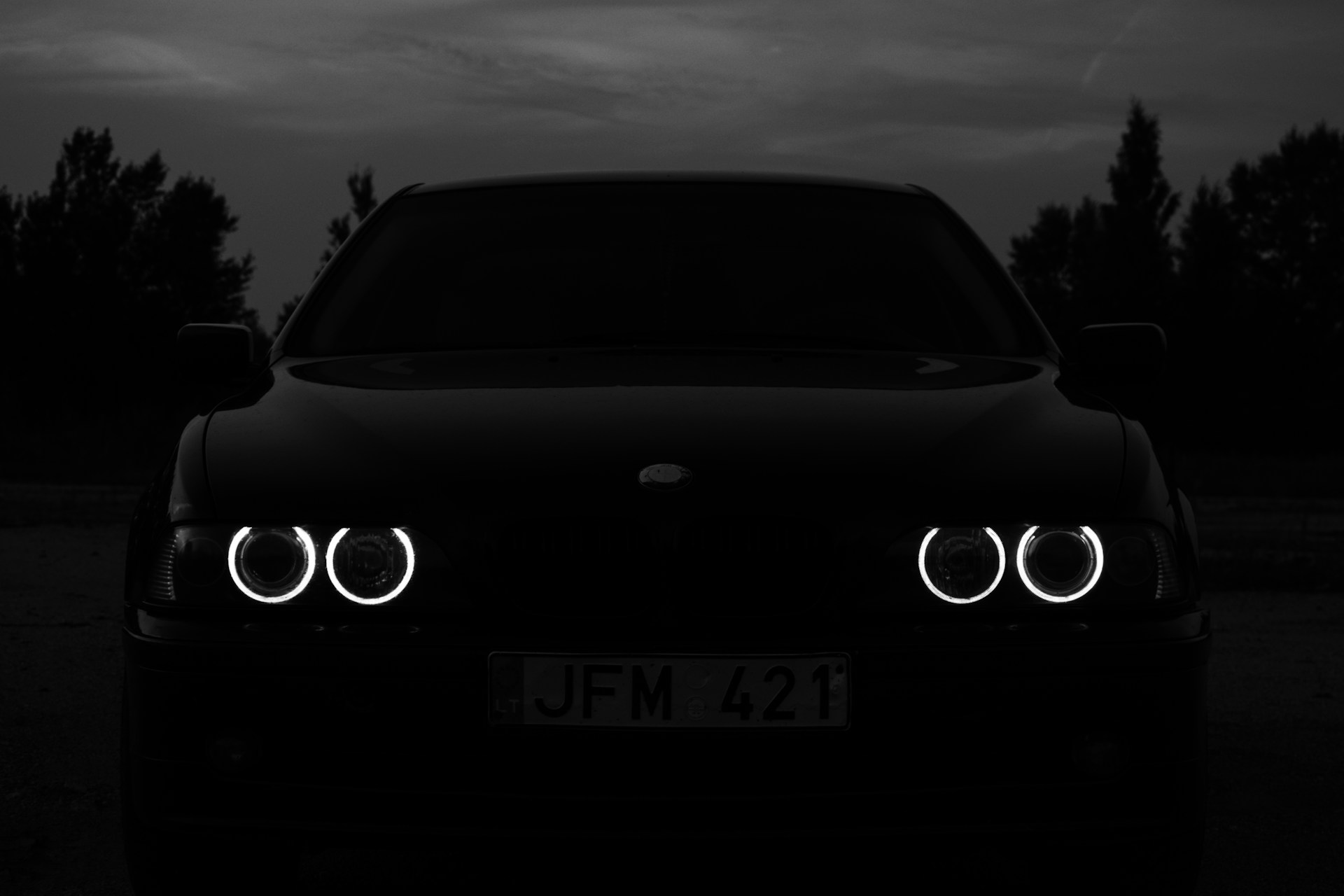 a black car with its lights on in the dark