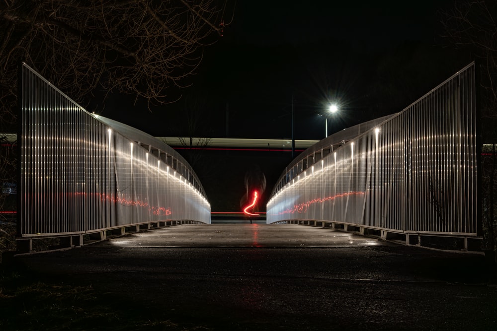 a person walking across a bridge at night