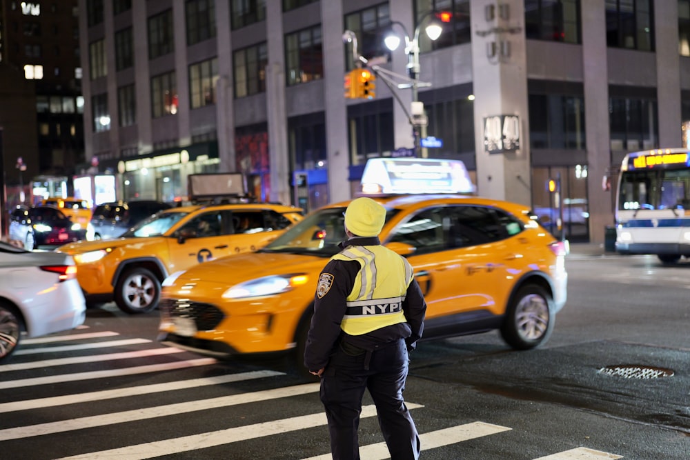 a man in a yellow vest is crossing the street