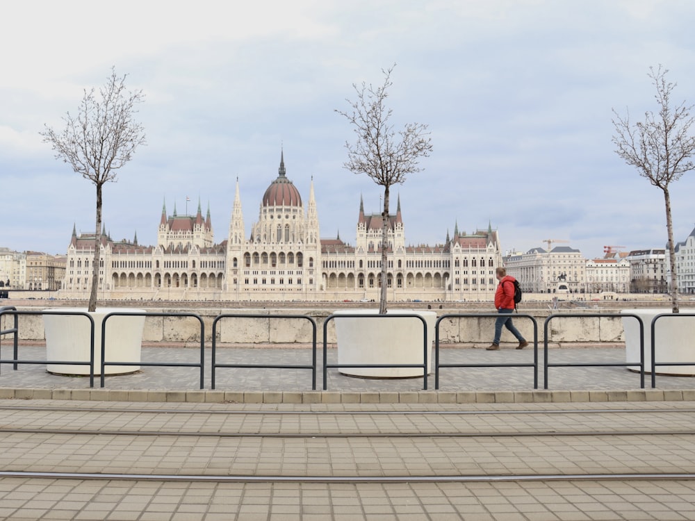 a man walking across a bridge over a river