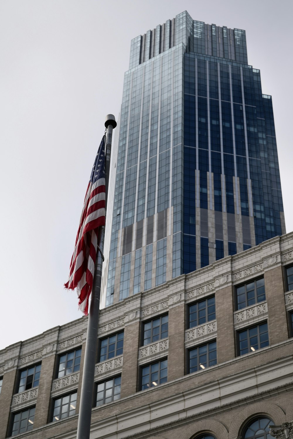 an american flag flying in front of a tall building