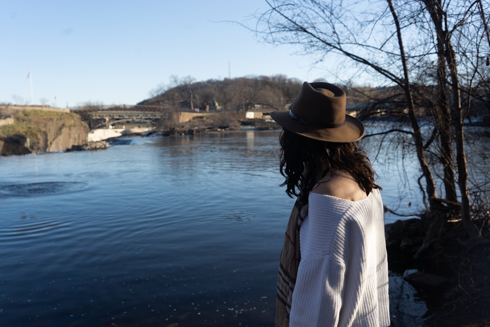 a woman standing in front of a body of water