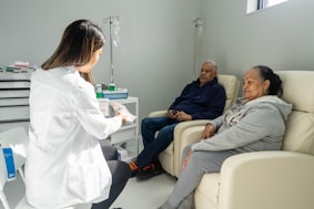 a woman in a white lab coat talking to a patient