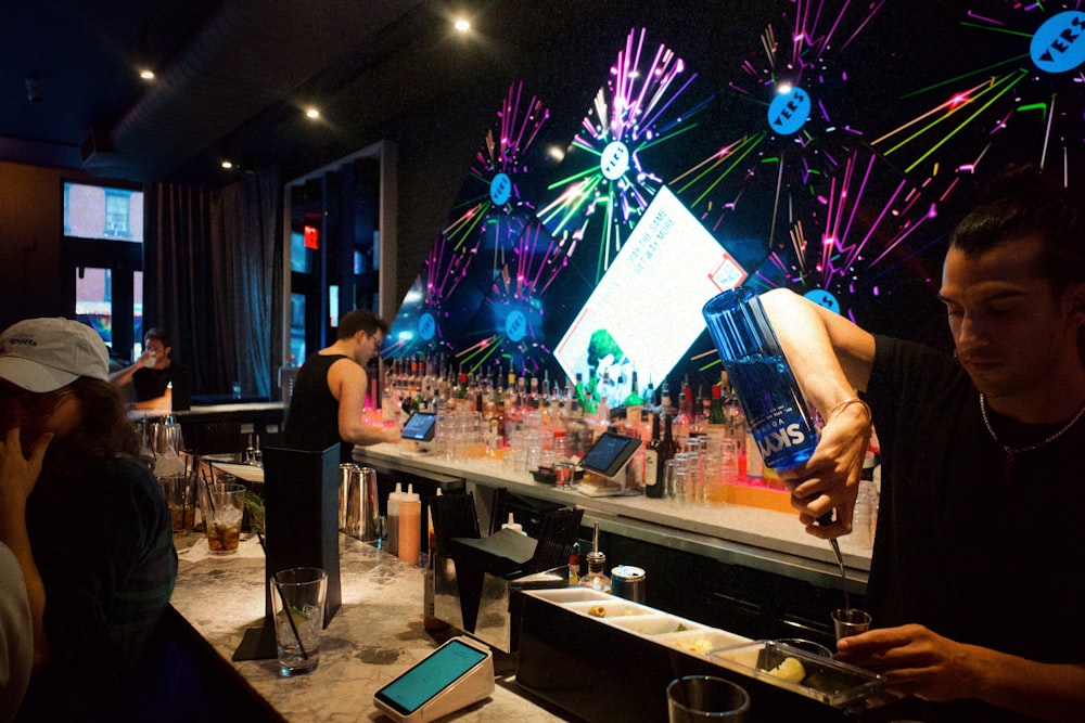 a man pouring a drink at a bar