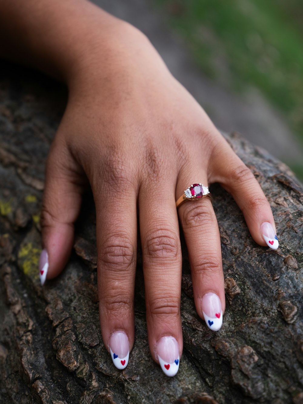 a woman's hand with a ring on top of a rock