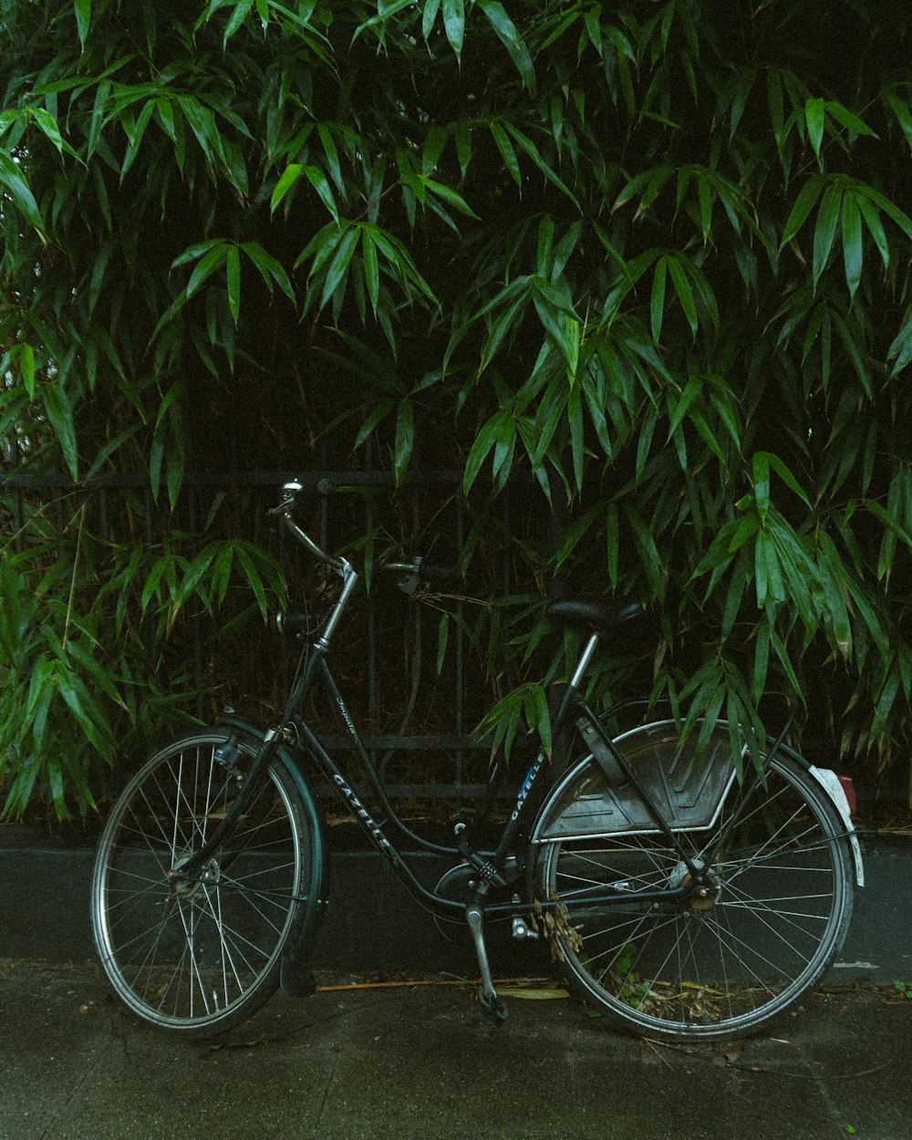 a bicycle is parked next to a fence