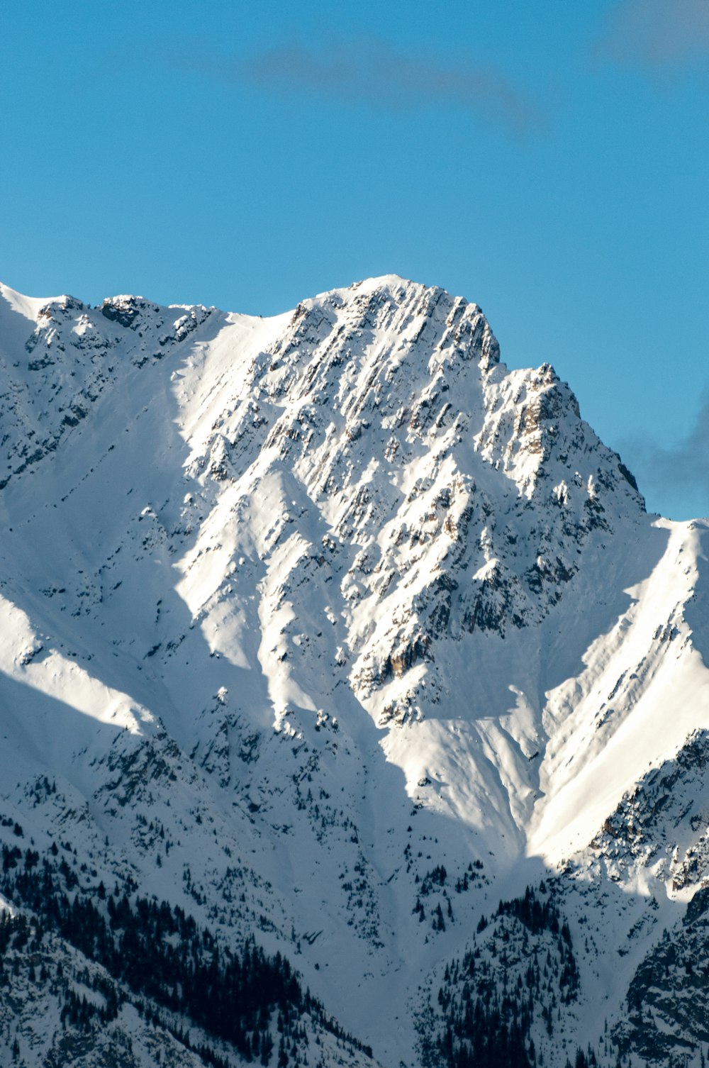 a mountain covered in snow under a blue sky