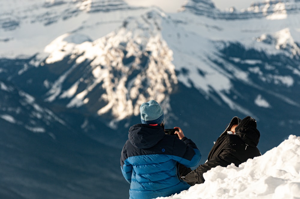 a man sitting on top of a snow covered mountain