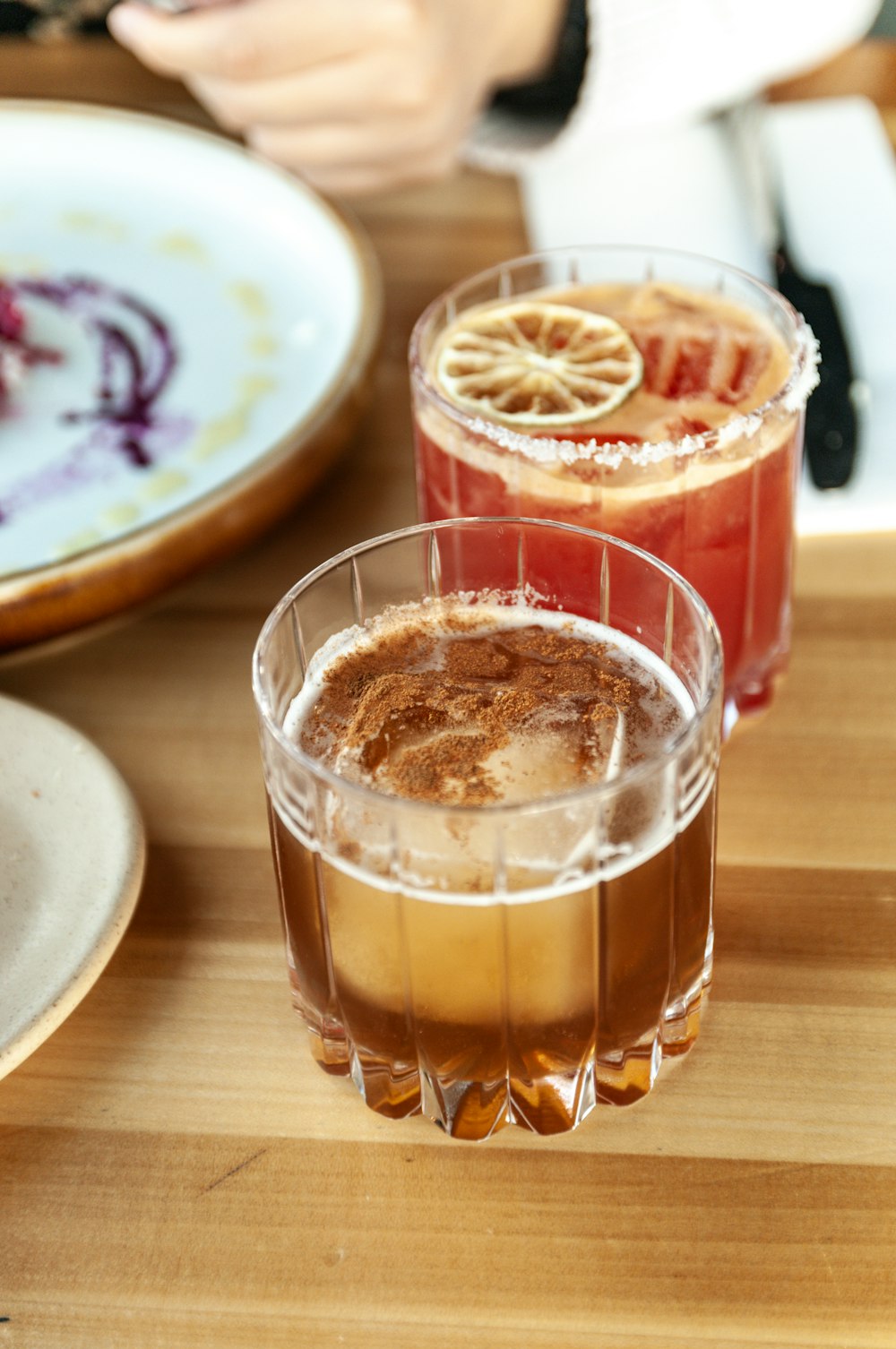 three drinks are sitting on a wooden table