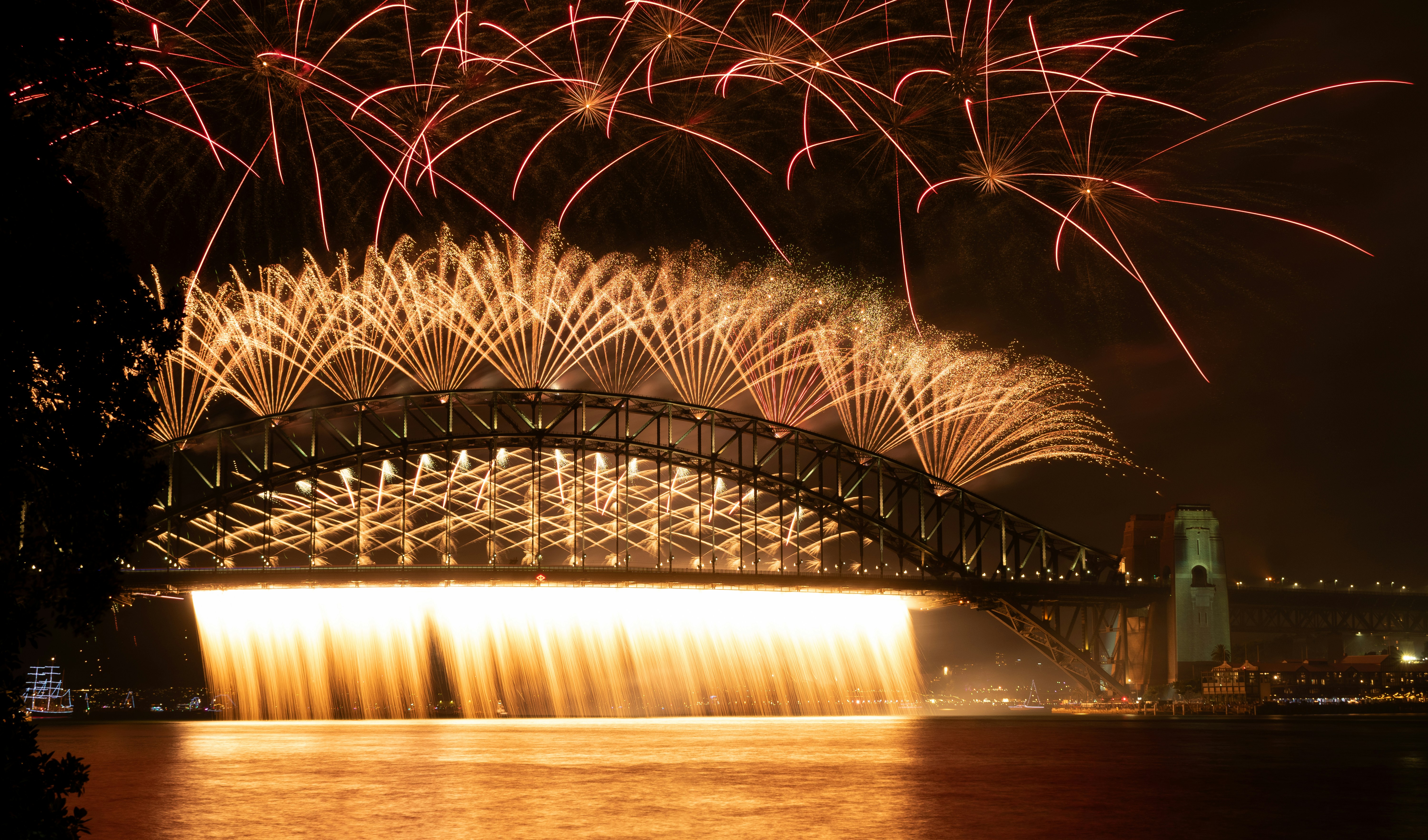 Fireworks are lit up in the sky above a bridge photo Free Sydney
