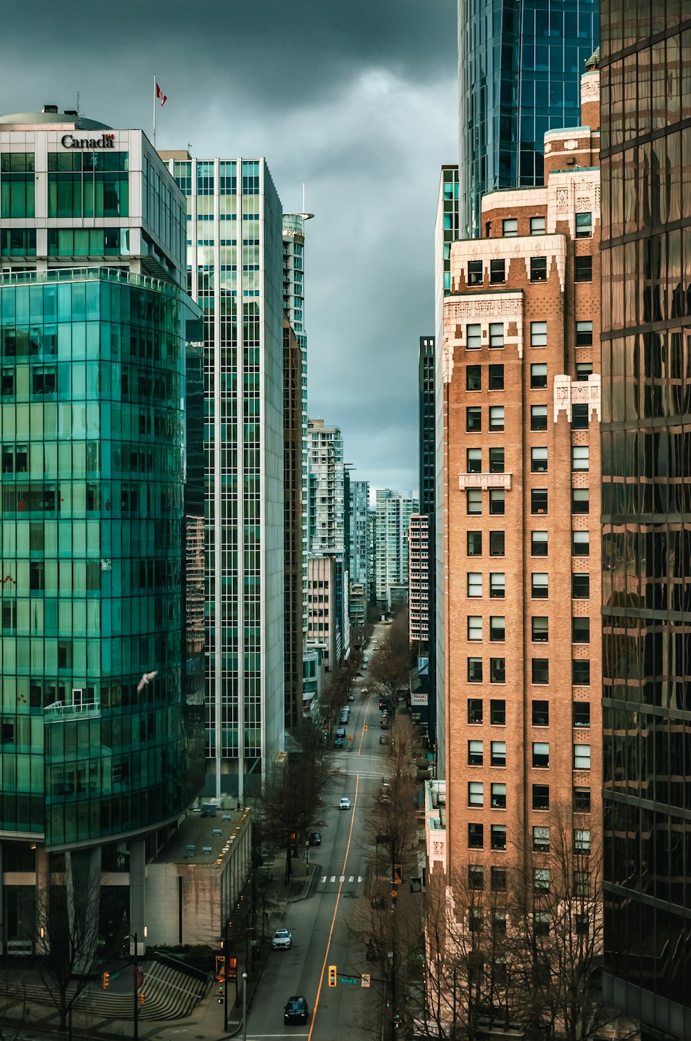 a city street with tall buildings and a cloudy sky