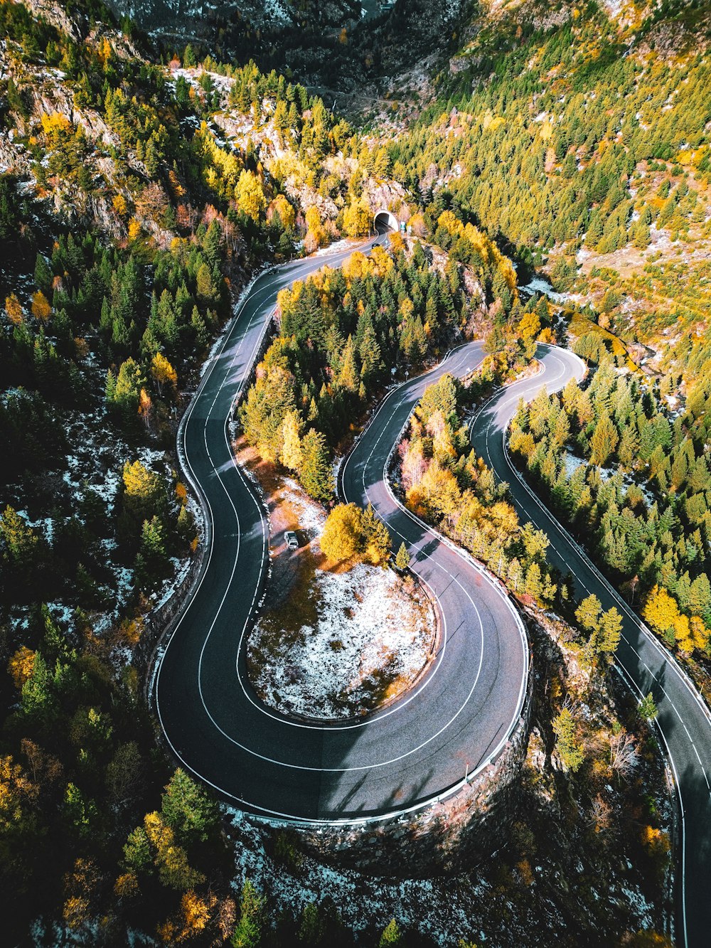 an aerial view of a winding road surrounded by trees