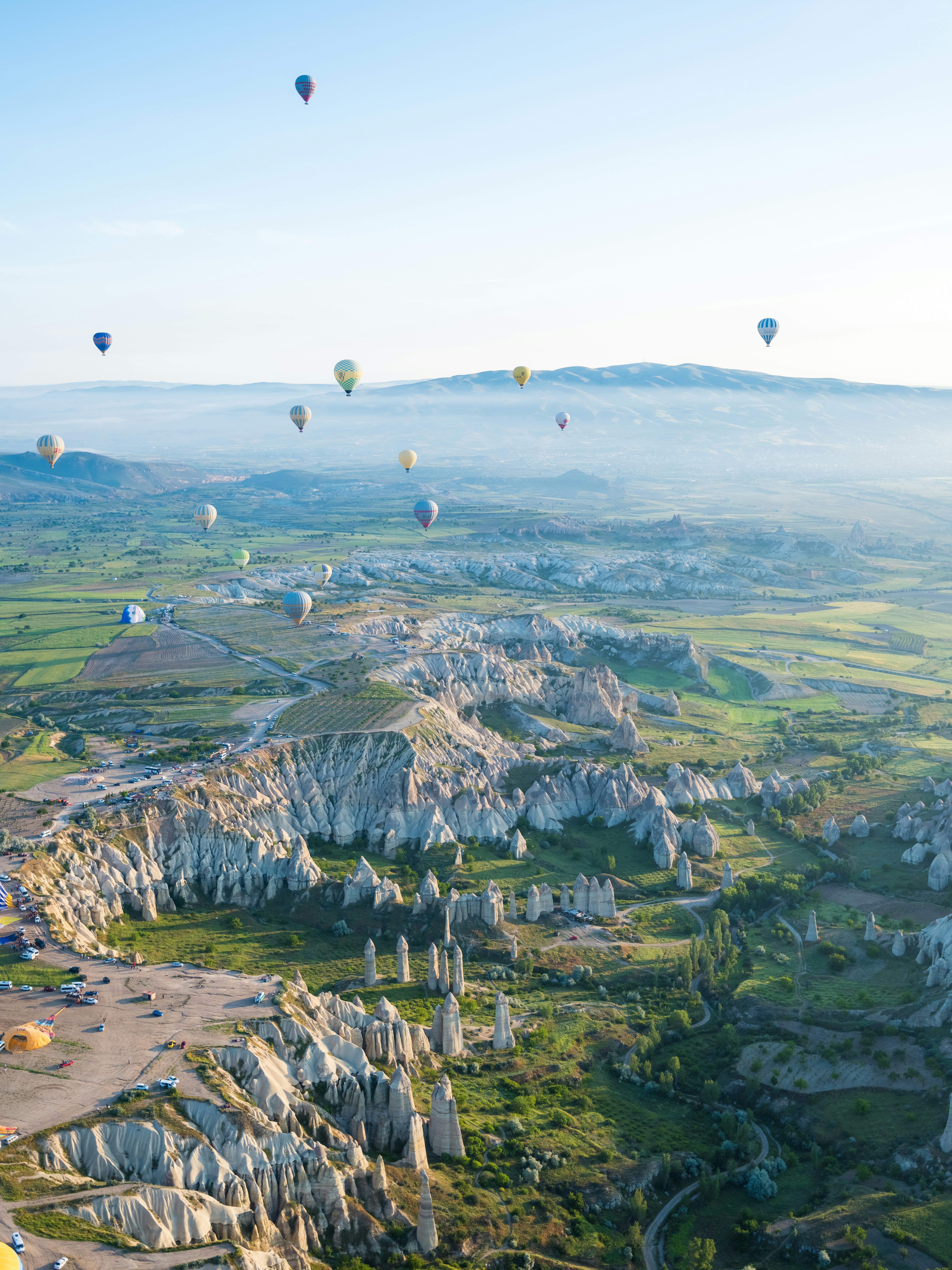 a group of hot air balloons flying over a valley