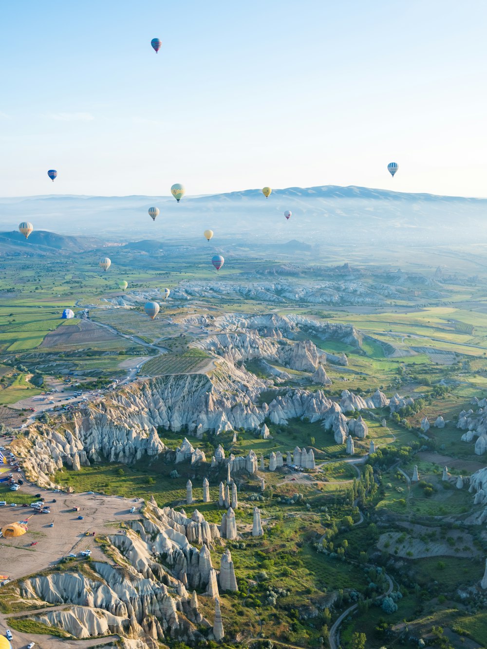 a group of hot air balloons flying over a valley