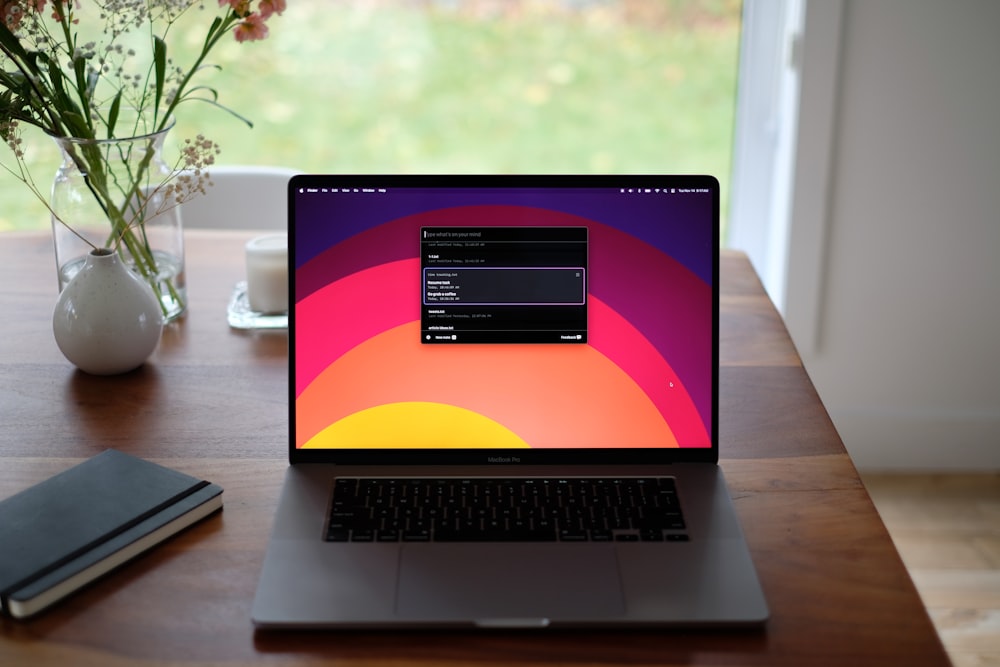 a laptop computer sitting on top of a wooden desk