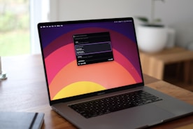 a laptop computer sitting on top of a wooden table
