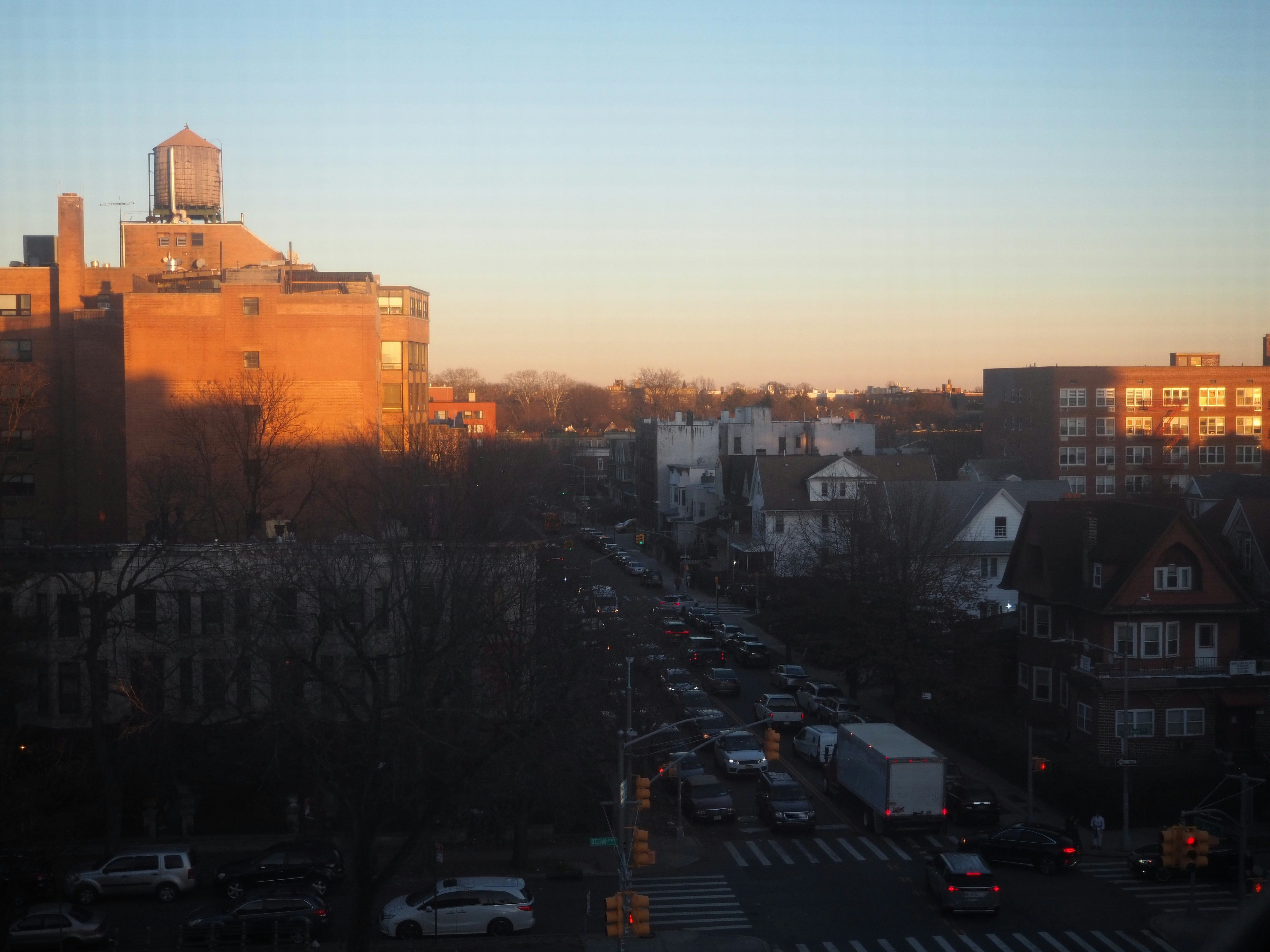 a city street filled with lots of traffic next to tall buildings