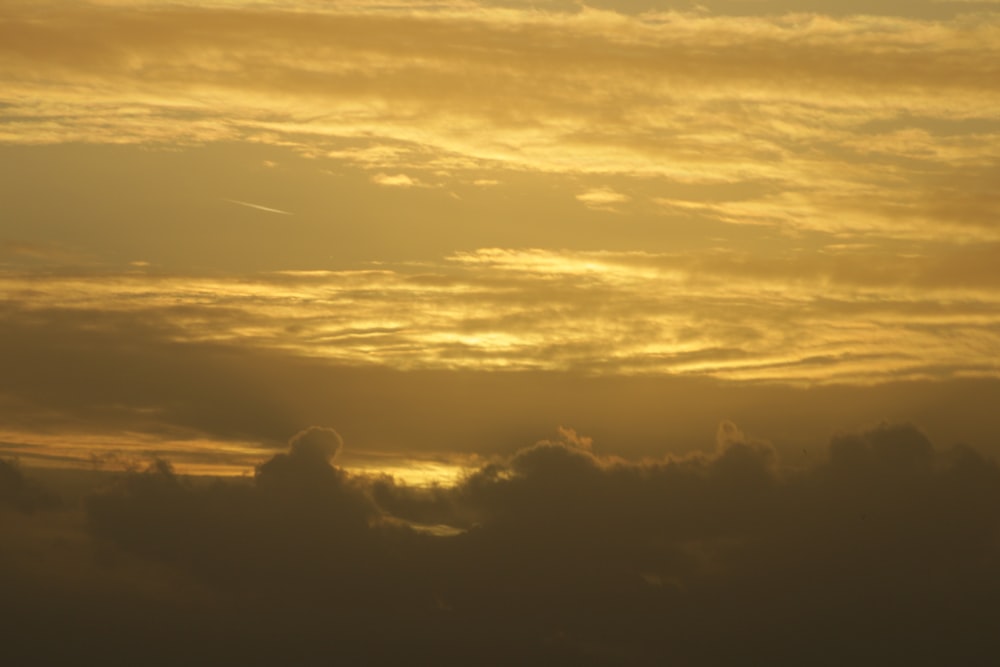 a plane flying in the sky at sunset