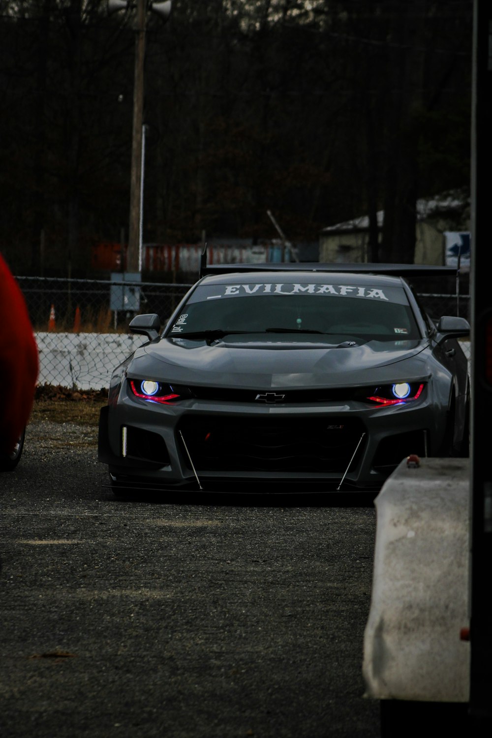 a car driving down a street next to a fence