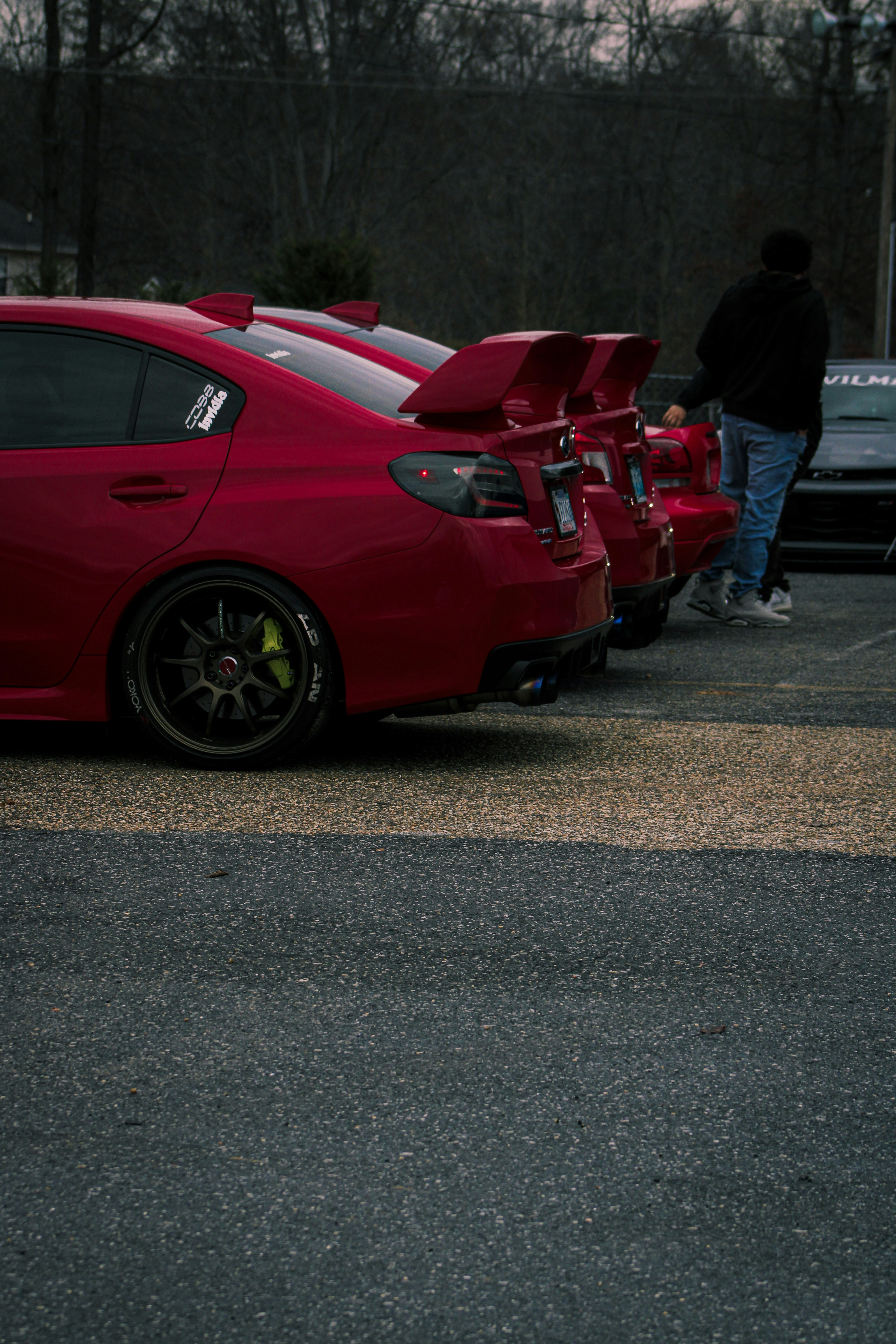a red car parked in a parking lot next to other cars