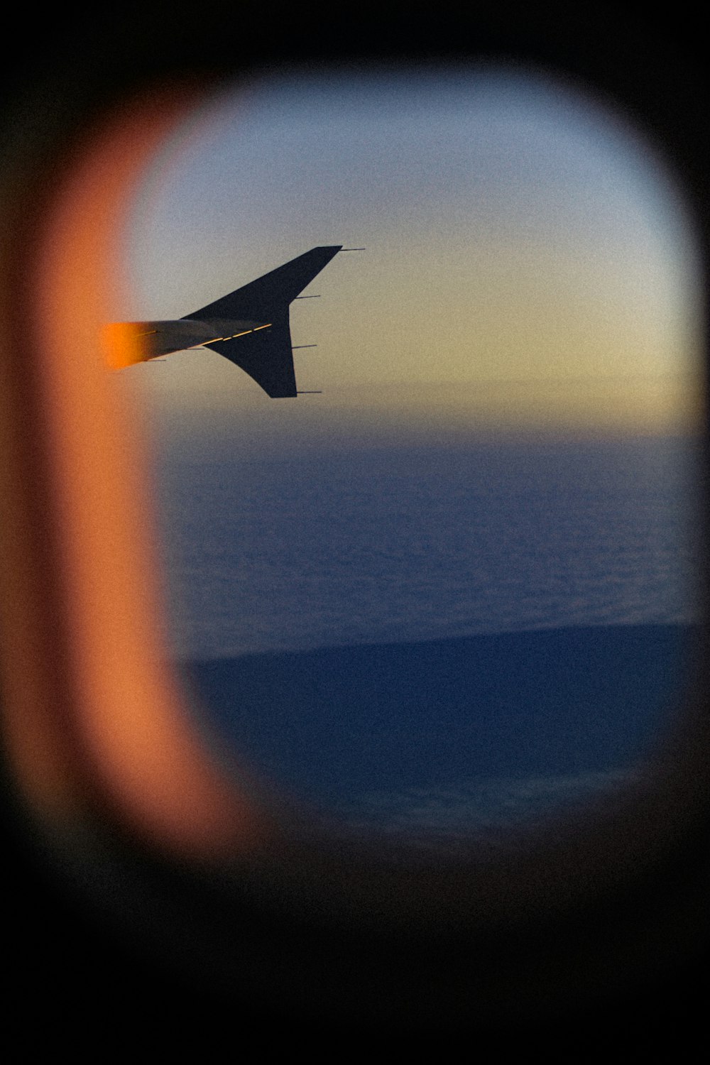 a view of the wing of an airplane as it flies over the ocean