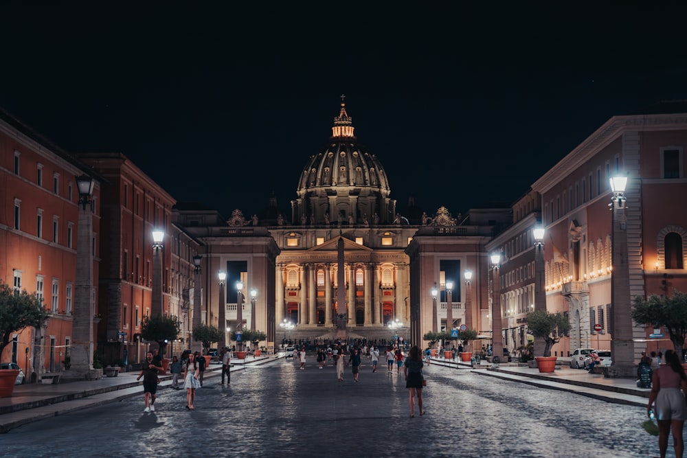 a group of people walking down a street at night