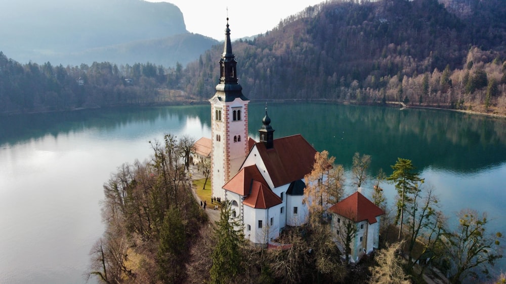 an aerial view of a church on an island in the middle of a lake