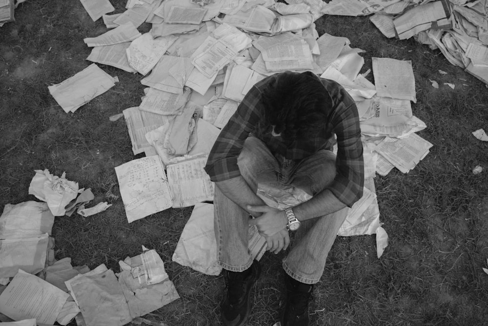 a man sitting on top of a pile of papers
